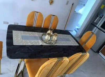 a dining room table with chairs and two figurines on it at Acogedor Sweet Apartament in Santiago de los Caballeros