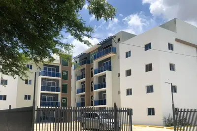 an apartment building with a fence in front of it at Acogedor Sweet Apartament in Santiago de los Caballeros