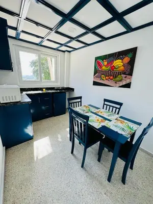 a kitchen with a blue table and two chairs at Mango y Jobo - Relaxed Mountain & Sea Panoramic view - 10mins drive to beach and city in San Felipe de Puerto Plata
