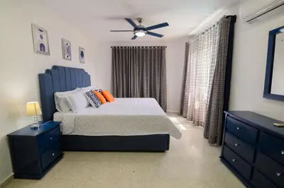 a bedroom with a bed and a ceiling fan at Mango y Jobo - Relaxed Mountain & Sea Panoramic view - 10mins drive to beach and city in San Felipe de Puerto Plata