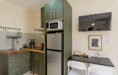 a small kitchen with a refrigerator and a microwave at 3 Studios at Casa Areito in Santo Domingo