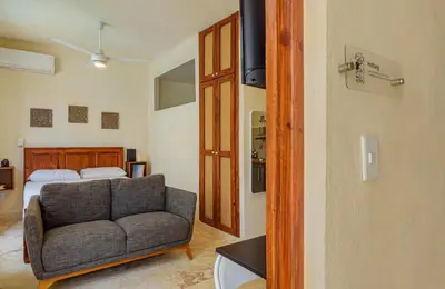 a living room with a couch and a bed at 3 Studios at Casa Areito in Santo Domingo