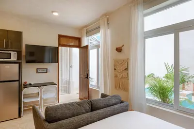 a living room with a couch and a kitchen at 3 Studios at Casa Areito in Santo Domingo