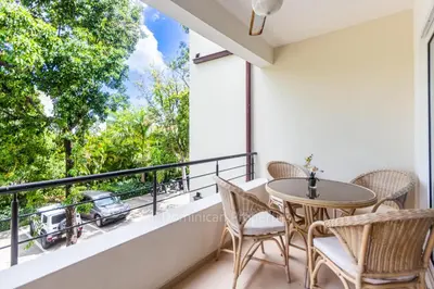 a balcony with a table and chairs and a view at Infiniti Blu, Sosua in Sosúa