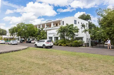 a white building with cars parked in front of it at Infiniti Blu, Sosua in Sosúa