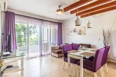 a living room with a table and purple chairs at Infiniti Blu, Sosua in Sosúa