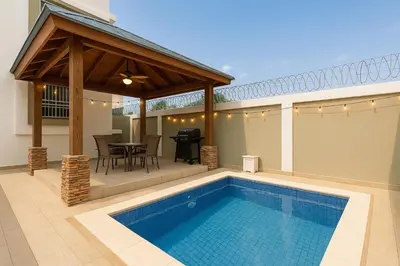 a patio with a swimming pool and a pavilion at Luxury Sky Blue in Jarabacoa