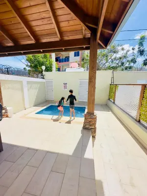 two children are playing in a swimming pool at Luxury Sky Blue in Jarabacoa