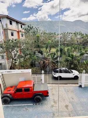 a red truck parked on a balcony with a white car at Luxury Sky Blue in Jarabacoa