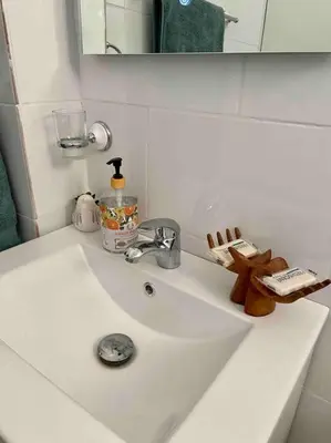 a white sink in a bathroom with a mirror at Nice and Breezy Apartment in Santiago de los Caballeros