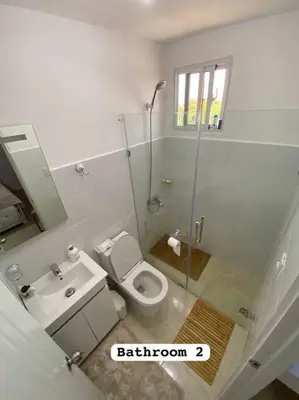 a bathroom with a shower and a toilet and a sink at Nice and Breezy Apartment in Santiago de los Caballeros