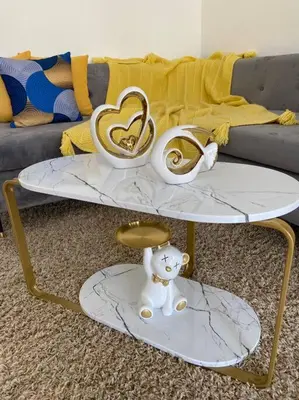 a coffee table with two gold and white items on it at Nice and Breezy Apartment in Santiago de los Caballeros