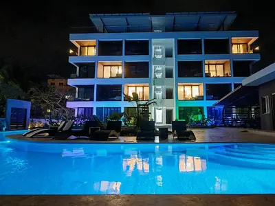 a large apartment building with a swimming pool at night at Surf One in Sosúa