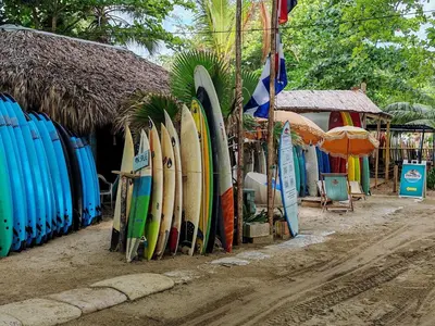 a bunch of surfboards are lined up on a street at Surf One in Sosúa