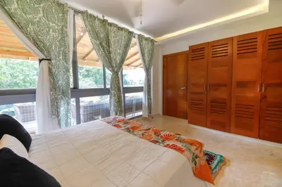a bedroom with a bed and a large window at Villa loren A3 in Las Terrenas