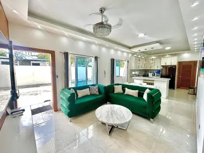 a living room with a green couch and a table at Elegante Apartamento A 100 mts la playa de los Minos RSJ in Río San Juan