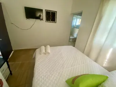 a bedroom with a white bed with a green pillow at Casa Tipo Villa, Piscina, Playas De RSJ a 4 min in Río San Juan