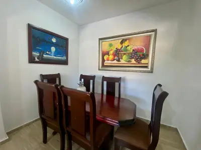 a dining room table with chairs and a painting on the wall at Casa Tipo Villa, Piscina, Playas De RSJ a 4 min in Río San Juan