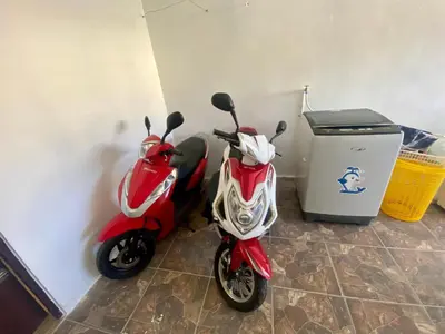 a red and white scooter parked next to a trash can at Casa Tipo Villa, Piscina, Playas De RSJ a 4 min in Río San Juan