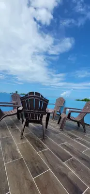 a table and chairs sitting on a patio overlooking the ocean at Residencial Doña Gloria 2 in San Felipe de Puerto Plata
