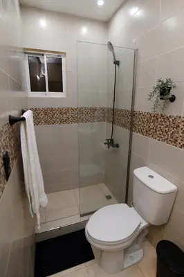 a bathroom with a toilet and a glass shower at Solmi Rooms in Calero
