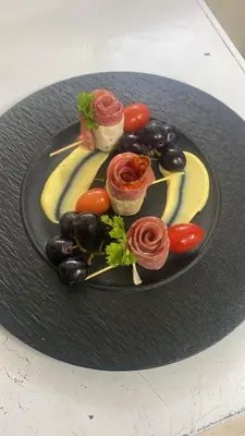 a black plate of food with tomatoes and olives at Solmi Rooms in Calero