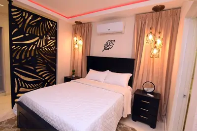 a bedroom with a white bed and a black and white wall at Solmi Rooms in Calero