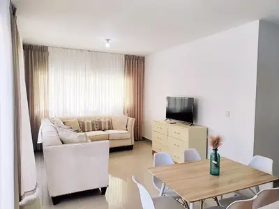 a living room with a couch and a table and chairs at Confortable Apartamento con Piscina en Cabrera in Cabrera