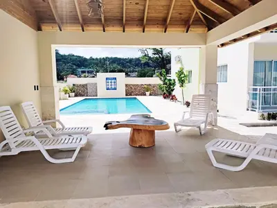 a patio with chairs and a table and a pool at Confortable Apartamento con Piscina en Cabrera in Cabrera