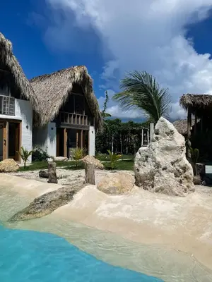 a house on the beach with a large rock in front at Blue Beach Eco-Hotel by Sanfabini in Bayahibe