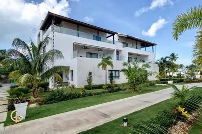 a white house with a dog in front of it at Golden Penthouse by Amar'e in Las Terrenas