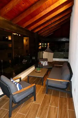 a porch with two couches and a table at Golden Penthouse by Amar'e in Las Terrenas