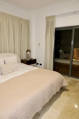 a bedroom with a large white bed and a window at Golden Penthouse by Amar'e in Las Terrenas