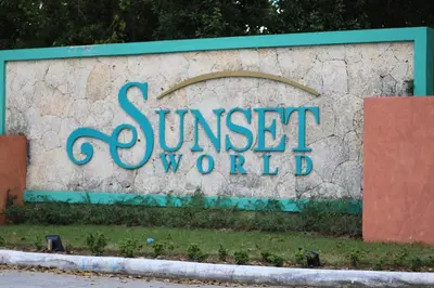 a sign for sunset world on a stone wall at Apartamentos Essential Life con playa y piscina in Punta Cana