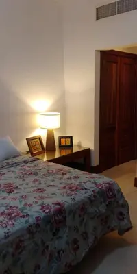 a bedroom with a bed and a lamp and a table at Apartamentos Essential Life con playa y piscina in Punta Cana