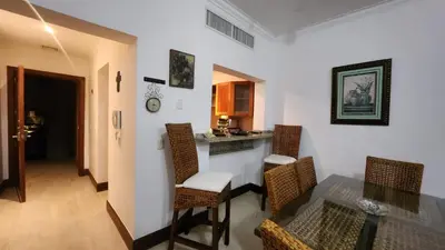 a room with a table and chairs and a kitchen at Apartamentos Essential Life con playa y piscina in Punta Cana