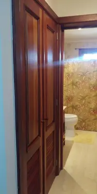 an open wooden door in a bathroom with a toilet at Apartamentos Essential Life con playa y piscina in Punta Cana