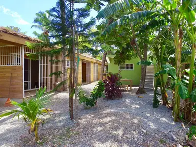 a building with trees in front of it at Mango House Camino laguna in Cabarete
