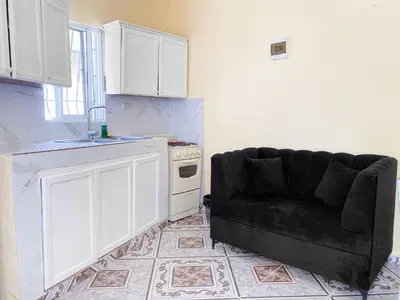 a living room with a couch in a kitchen at Guest House A&H in Boca Chica