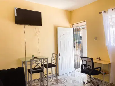 a room with a table and chairs and a television on the wall at Guest House A&H in Boca Chica