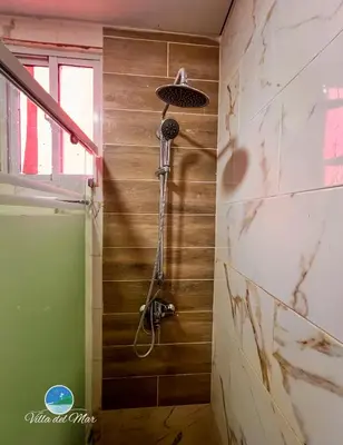 a shower in a bathroom with wooden walls at Villa del Mar in Santa Cruz de Barahona