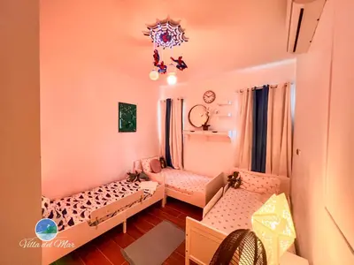 a small room with two beds and a chandelier at Villa del Mar in Santa Cruz de Barahona