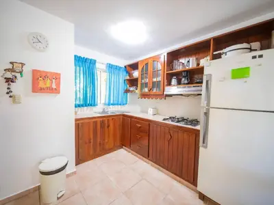 a kitchen with wooden cabinets and a white refrigerator at 2br Caribbean Condo In Cabarete Center in Cabarete
