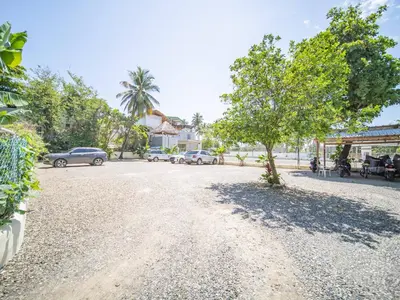 a gravel road with cars parked on the street at 2br Caribbean Condo In Cabarete Center in Cabarete