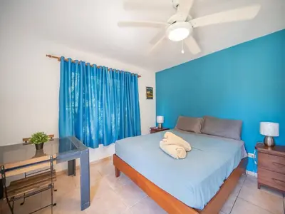 a blue bedroom with a bed and a desk at 2br Caribbean Condo In Cabarete Center in Cabarete
