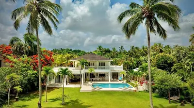 a house with a swimming pool and palm trees at Villa Azulsalado - Frente a la playa in Las Terrenas