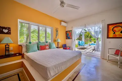 a bedroom with a bed and a large window at Villa Azulsalado - Frente a la playa in Las Terrenas