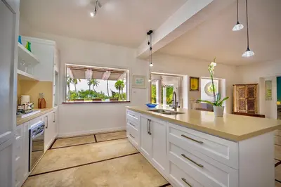 a kitchen with white cabinets and a large island at Villa Azulsalado - Frente a la playa in Las Terrenas