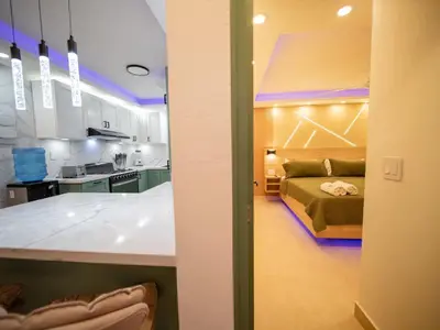 a kitchen and a bedroom with a bed in a room at Garden Condos 5- Luxurious Apartment In Sosua Center in Sosúa