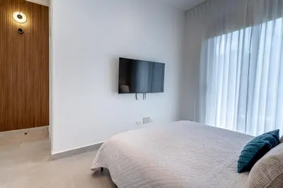 a bedroom with a bed and a tv on a wall at Elegant Seaside Villa Steps to Beach & Golf Course in Boca del Soco